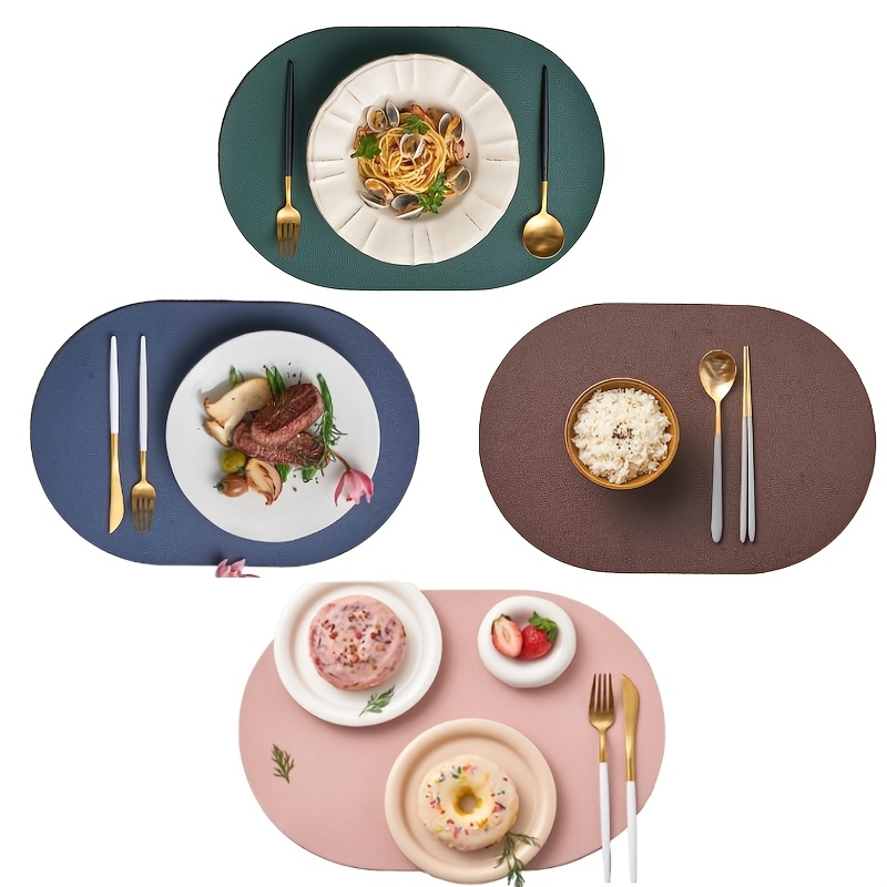 Four-piece set of oval faux leather placemats, reversible, heat resistant.