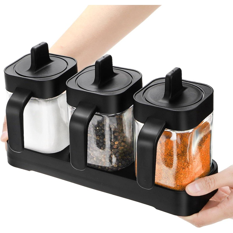 A set of three glass and wooden spice jars, with lids and spoons.